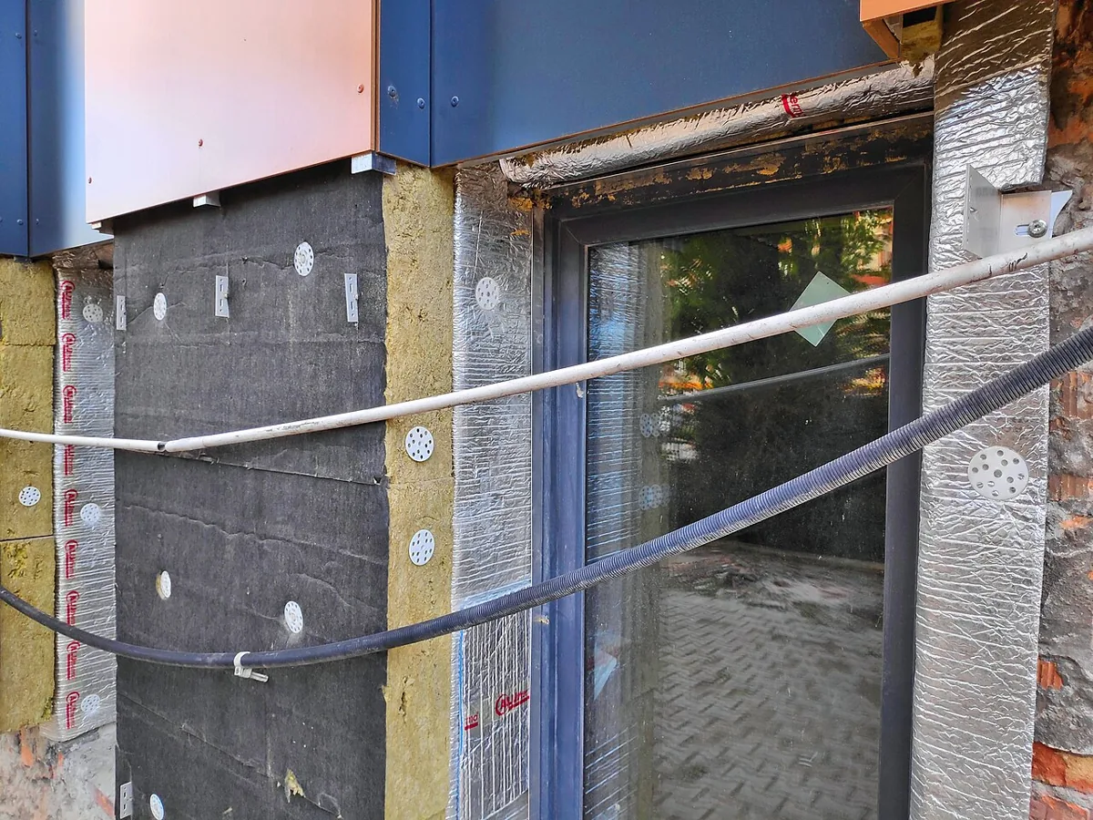 Aluthermo-folie en minerale wol tijdens een gevelrenovatie.
